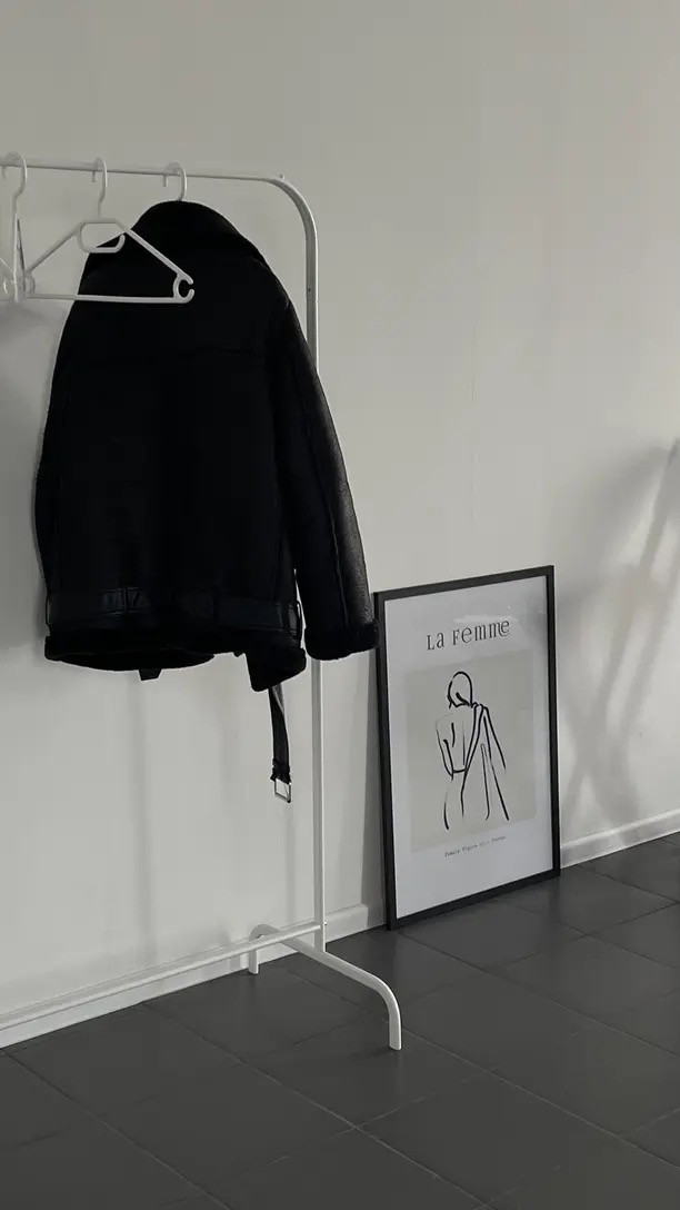 Casaco preto minimalista pendurado em arara