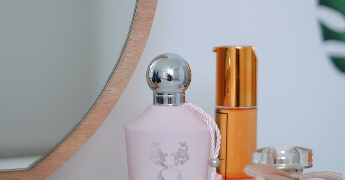 Penteadeira elegante com frascos de perfume diante de espelho