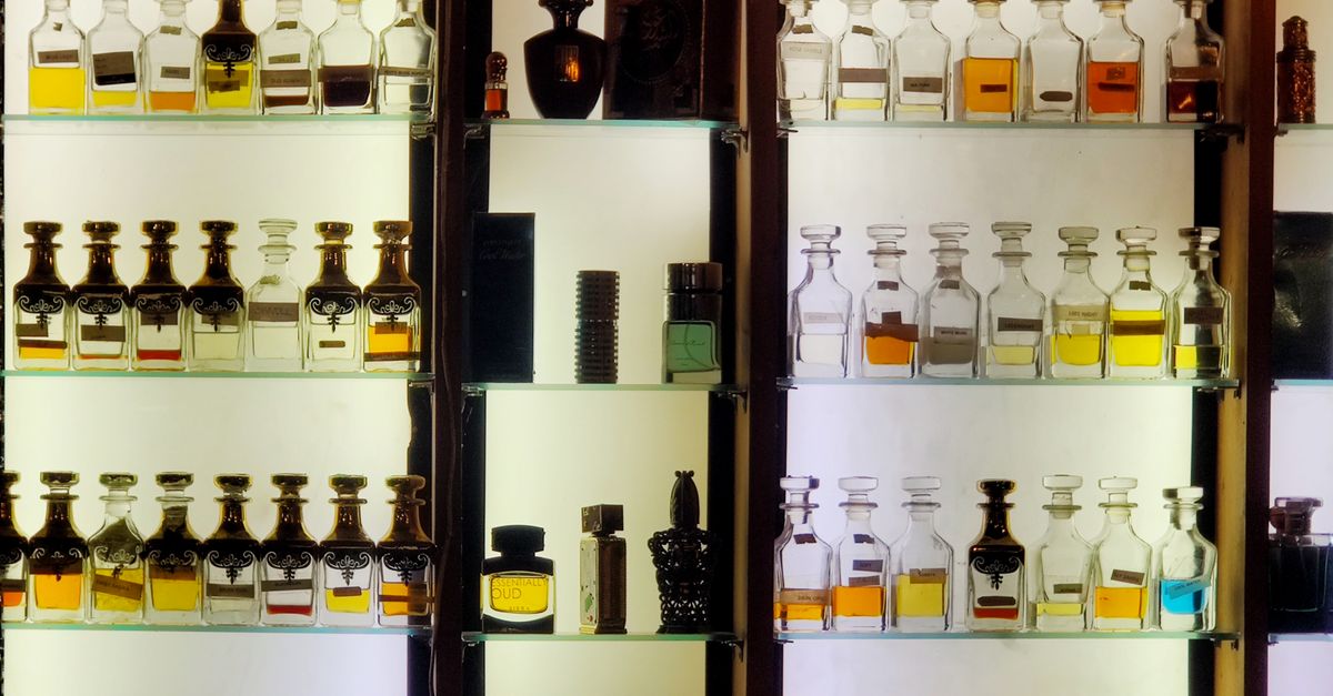Prateleiras iluminadas com frascos de perfume decantados em uma boutique